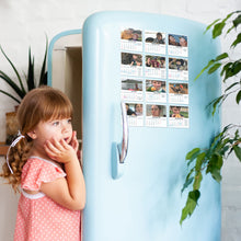 A child standing in front of a blue refrigerator with a magnetic calendar attached to it, showing images for each month of the year.
